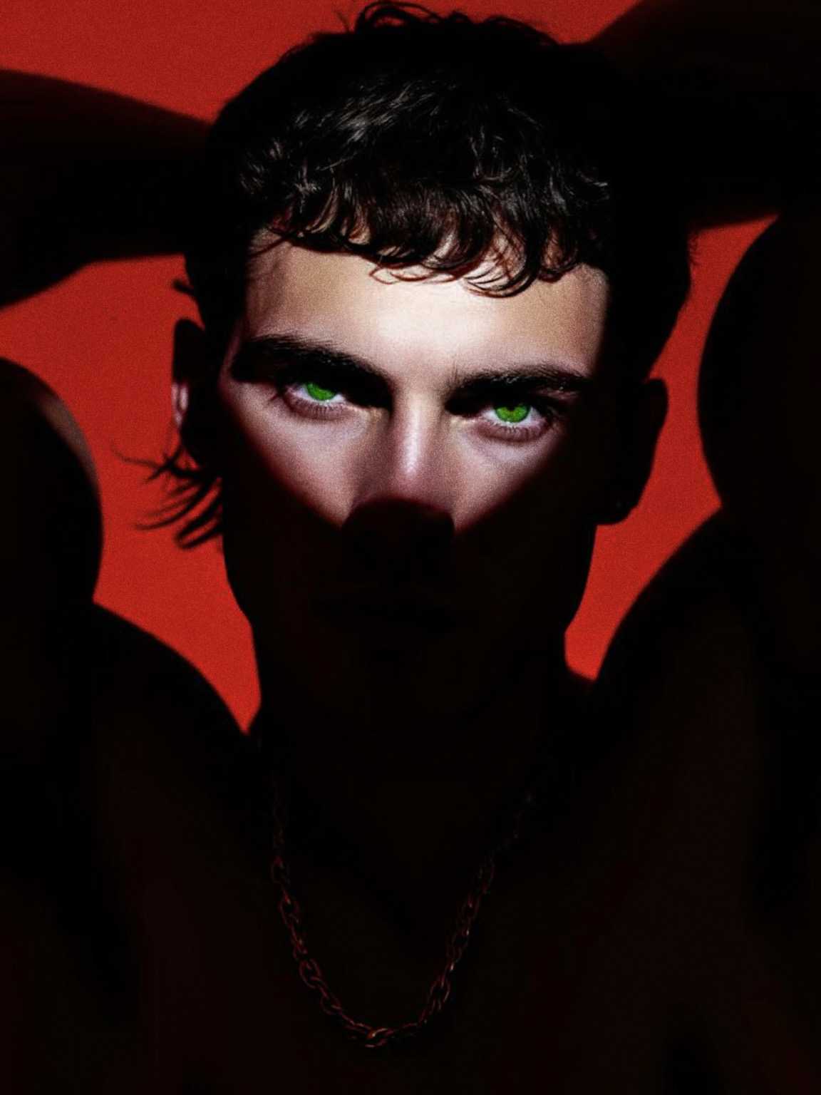 candid moment of Damon Cael adjusting his jacket in bright flash lighting, rising pop artist Damon Cael.